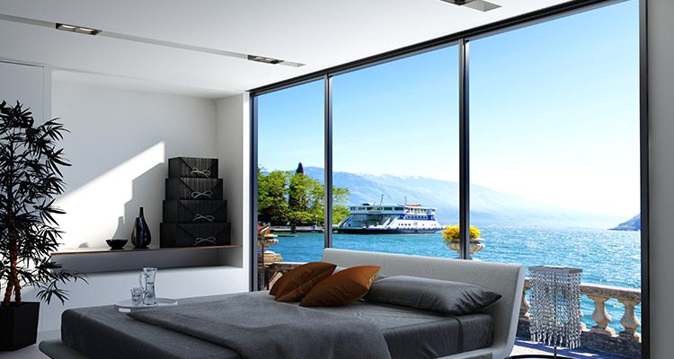ABM Windows & Doors large fixed windows in bedroom with views of the ocean behind bed