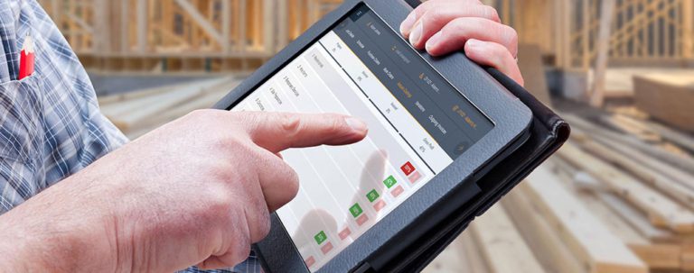 Buildxact software on tablet with construction building in the background