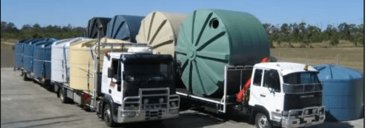 Two trucks loaded with multiple poly water tanks from Capital Tanks