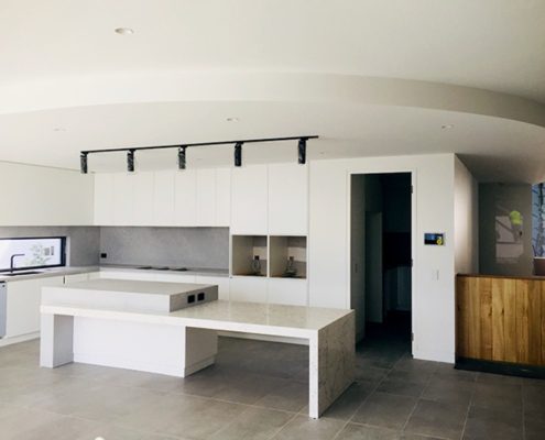 A kitchen in the middle of construction with a completed white curved bulk head from CHAD