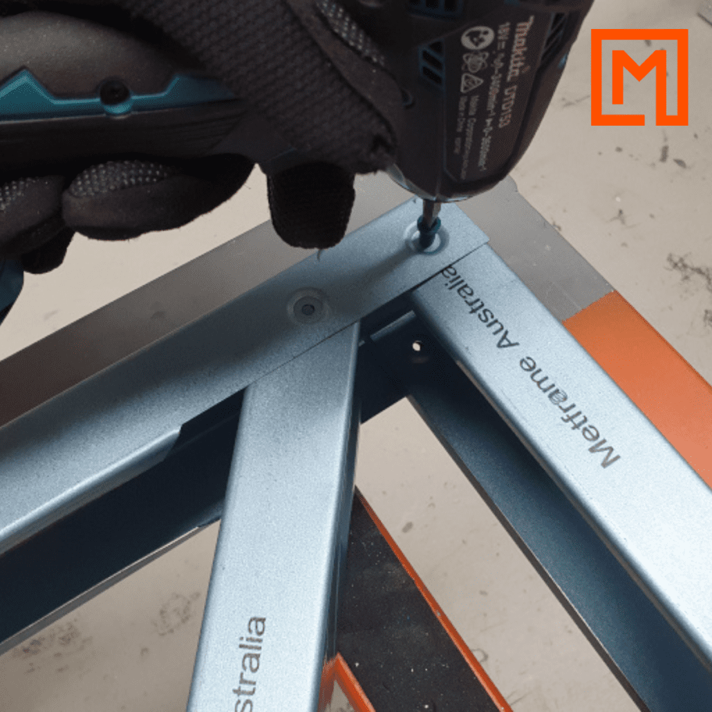 Metframe Australia prefabricating steel frames with a drill. Logo in top right corner