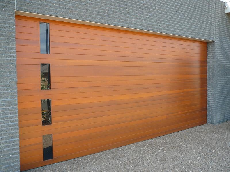Grey brick cladding with a timber look garage door with small vertically placed rectangular windows
