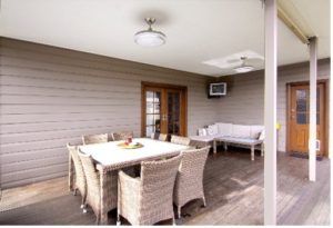 Neutral coloured horizontal cladding planks with outdoor table and couch