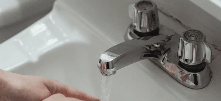 Washing hands in bathroom sink
