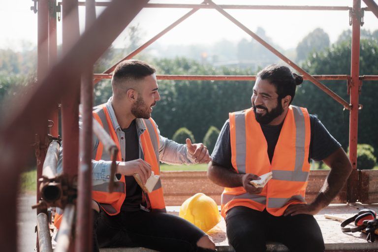 Two workers with high vis on sitting between scaffolding