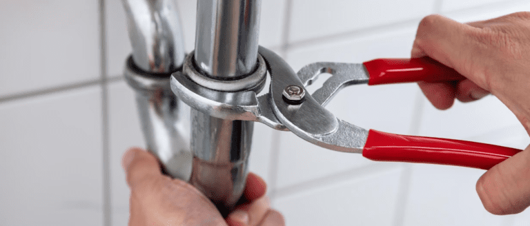 Close up of a play bets hands tinkering with a pipe with pliers
