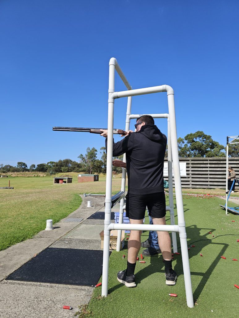 Member aiming gun at clay shooting day