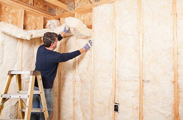 Man installing insulation inside timber framing