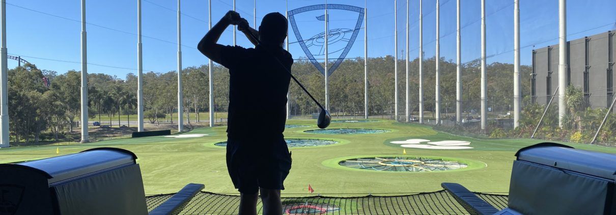 TopGolf TAG event silhouette of player hitting ball