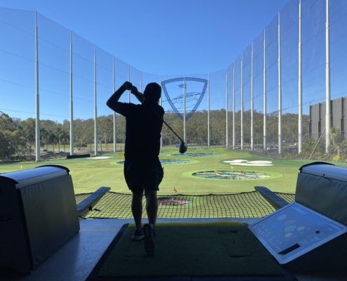 TopGolf TAG event silhouette of player hitting ball