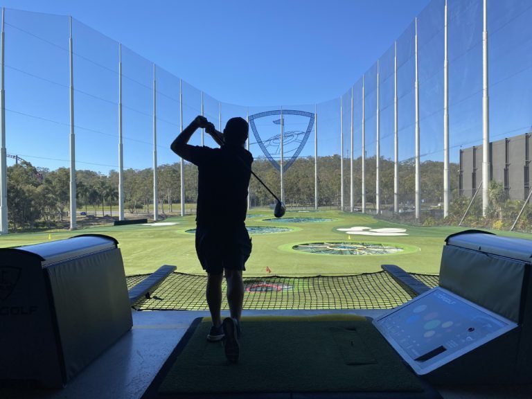 TopGolf TAG event silhouette of player hitting ball