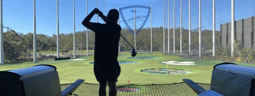 TopGolf TAG event silhouette of player hitting ball