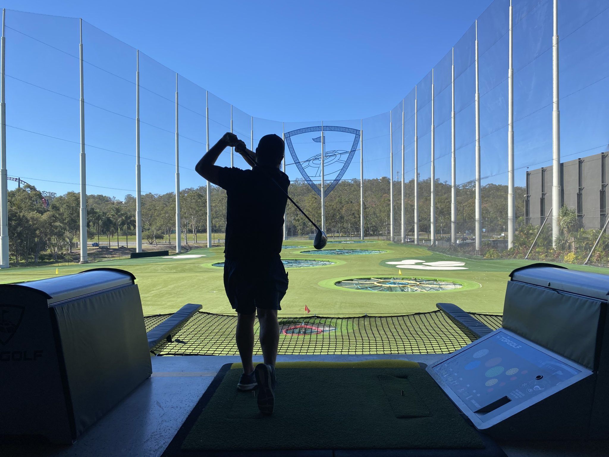 TopGolf TAG event silhouette of player hitting ball