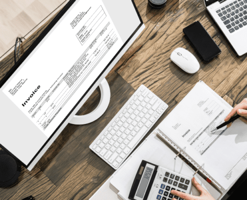 Worker at desk with paperwork and computer