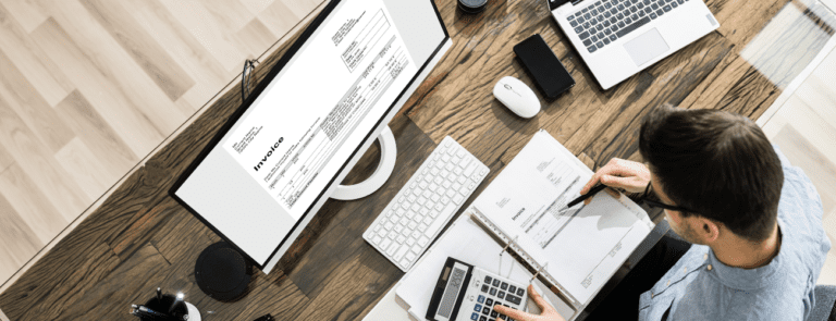 Worker at desk with paperwork and computer