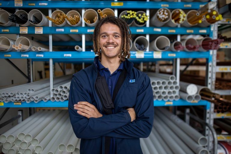 Tradelink feature image worker in front of pipes