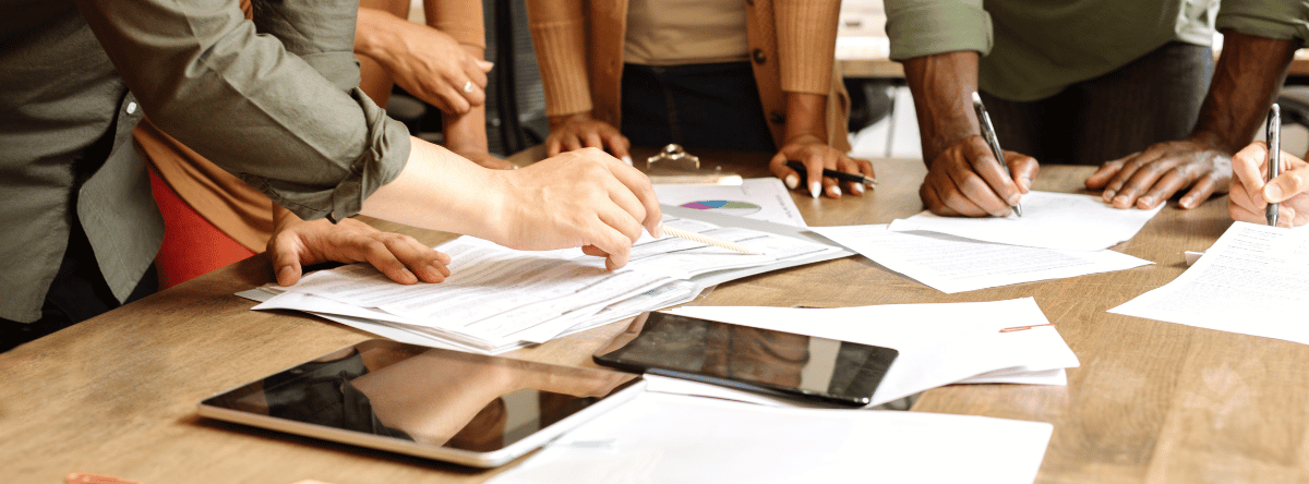 simplify social media strategy workers standing around desk with tablets