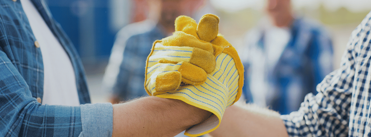 Two builders shaking hands with builders gloves on