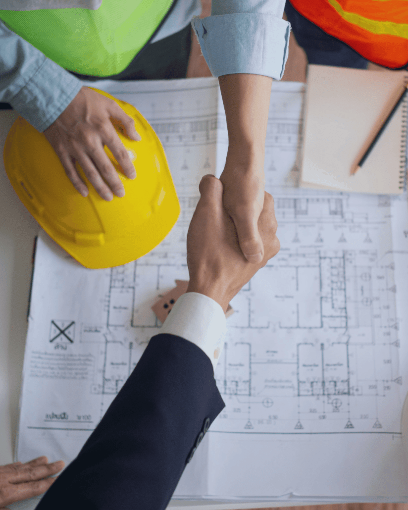 Builder and client shaking hands over paperwork