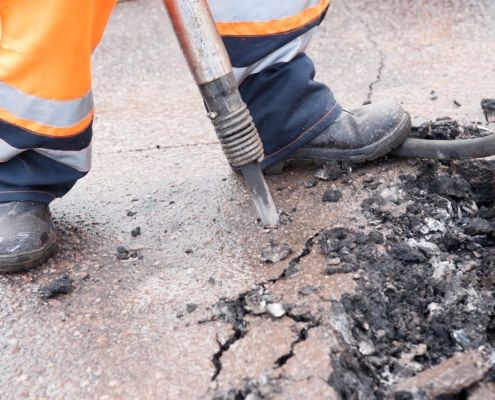 worker drilling into ground silica