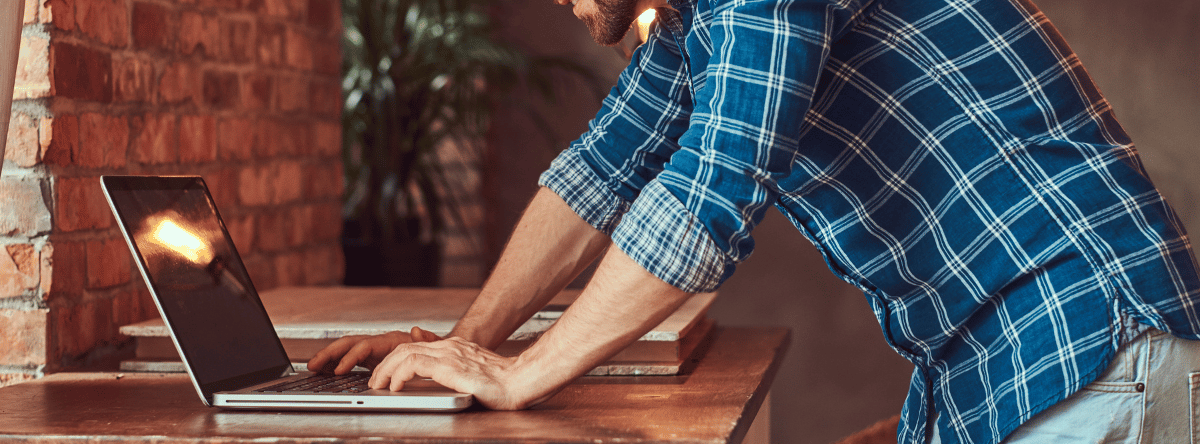 Newsletter Banner flannel shirt builder organising on laptop in workshop